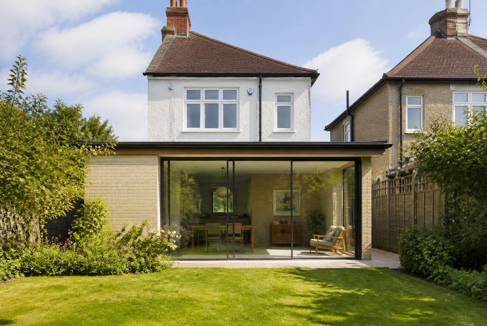 Low pale brick garden room on the rear of a 1930s house in Chalkwell, full width sliding glazing opening onto a lawn